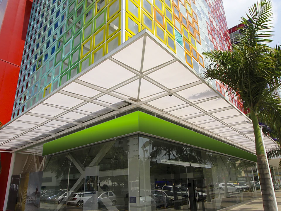 Cubierta fija en policarbonato con estructura blanca de aluminio sobre el acceso del Edificio de Colores, Cali