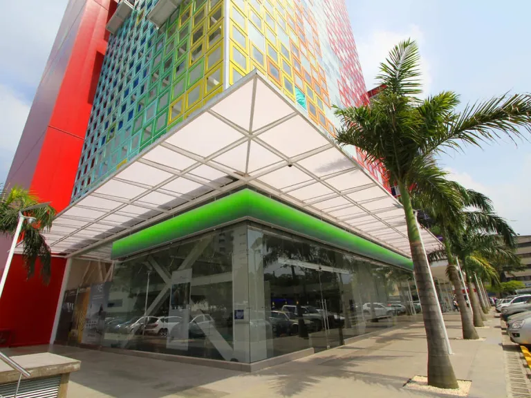 Cubierta en policarbonato con estructura en aluminio en la fachada del Edificio de Colores, Cali, vista desde la acera