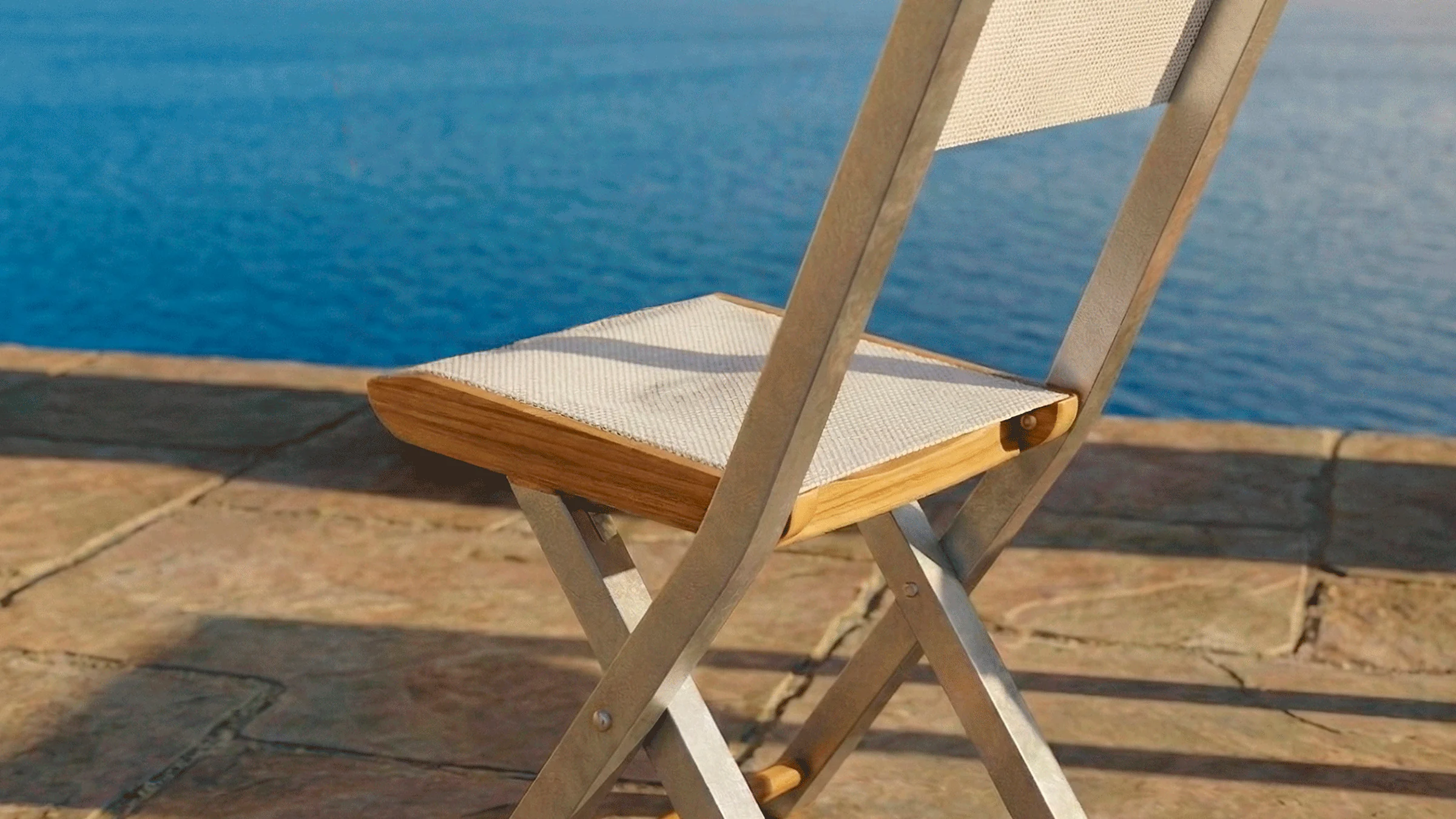 Silla plegable Kioto Malla Aluteca en madera teca, en una terraza