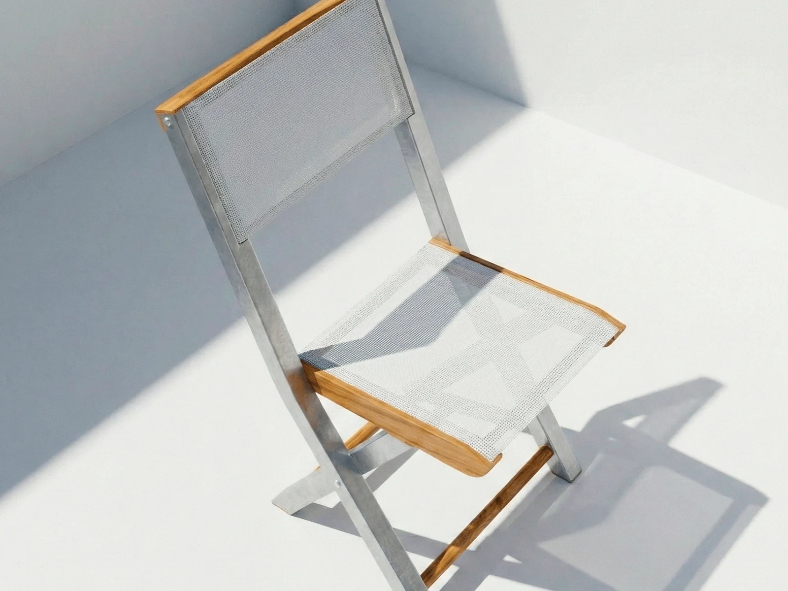 Silla plegable Kioto Malla Aluteca en madera teca, vista en perspectiva sobre fondo blanco de estudio
