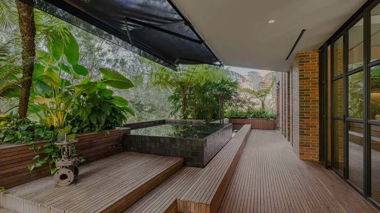 Toldo enrollable Sombralina de brazos invisibles extendido sobre la terraza en deck de madera del Edificio Gulungo, Cali