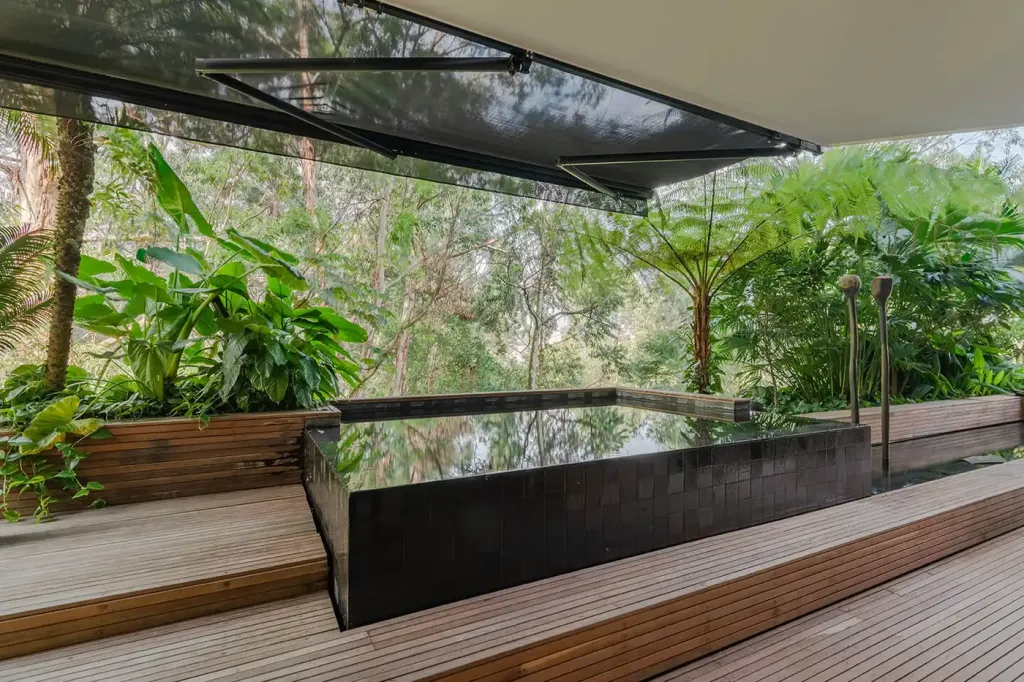 Sombralina extendida sobre el espejo de agua y el deck de madera de la terraza del Edificio Gulungo, Cali