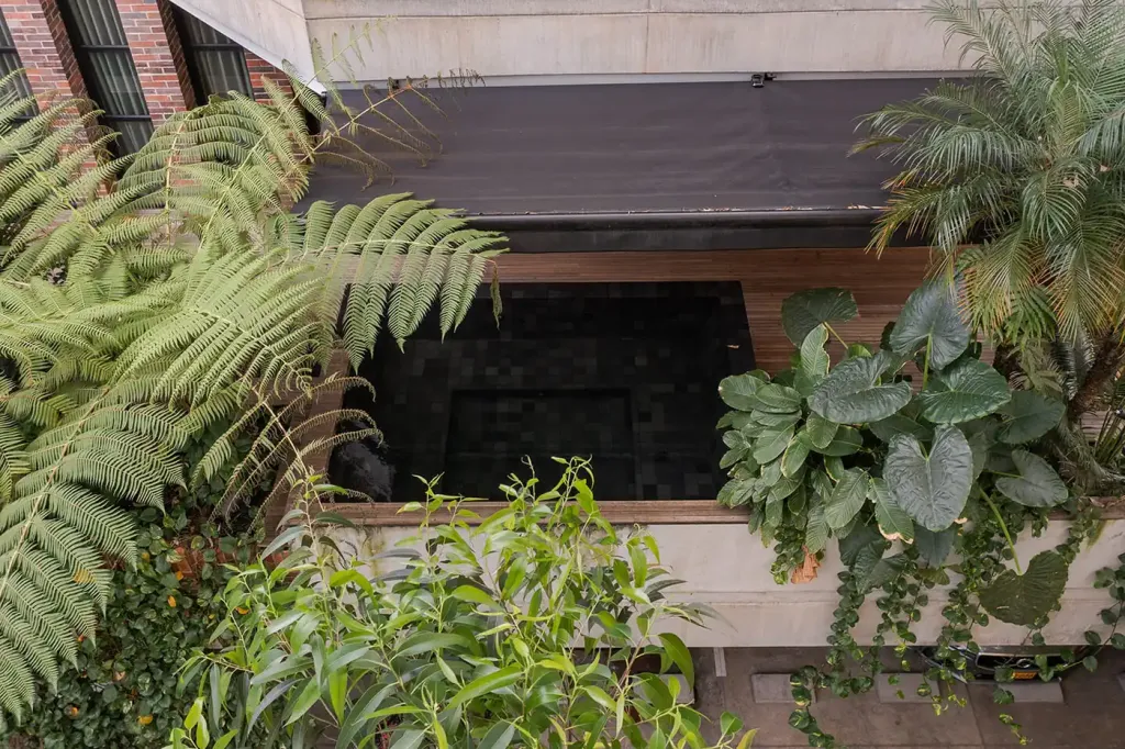Sombralina cubriendo el patio interior con vegetación del Edificio Gulungo, Cali