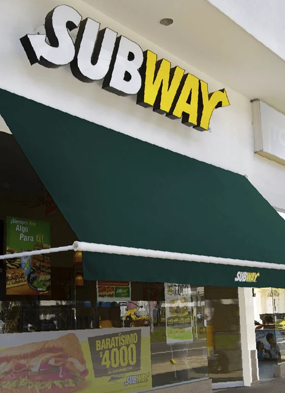 Toldo enrollable Baneta Proyectante en la fachada de un restaurante Subway, Bogotá