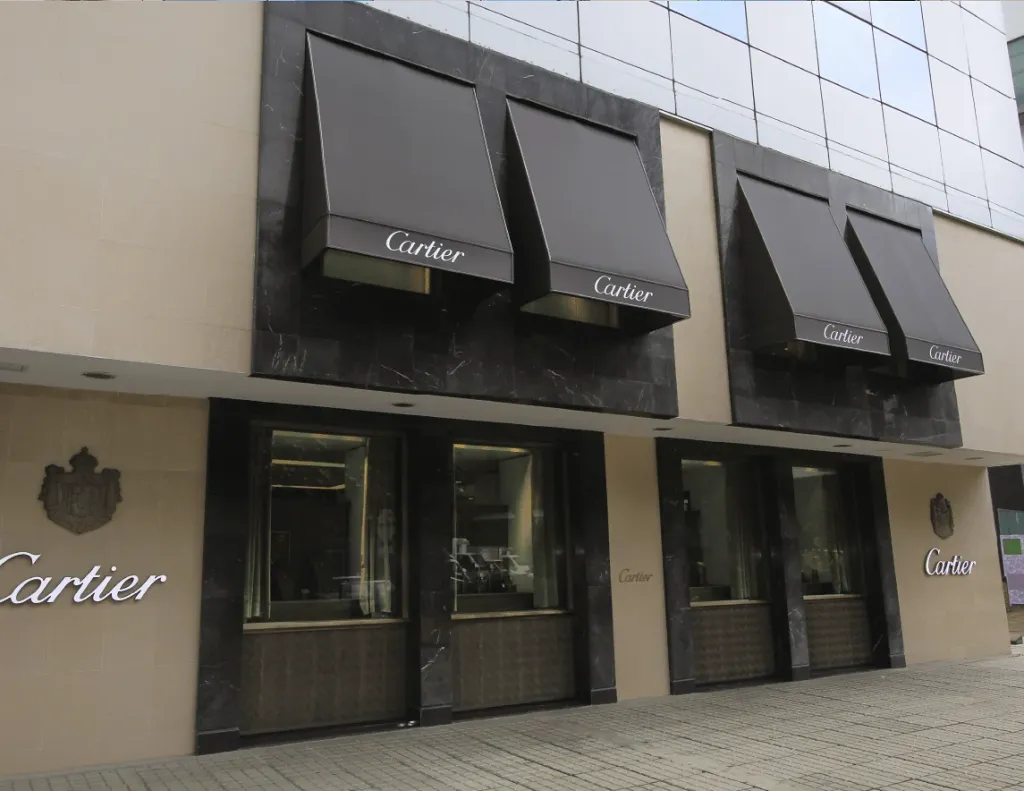 Toldo fijo Corbella en la fachada de la boutique Cartier de Bogotá: cuatro parasoles de lona tensada color café sobre las vitrinas