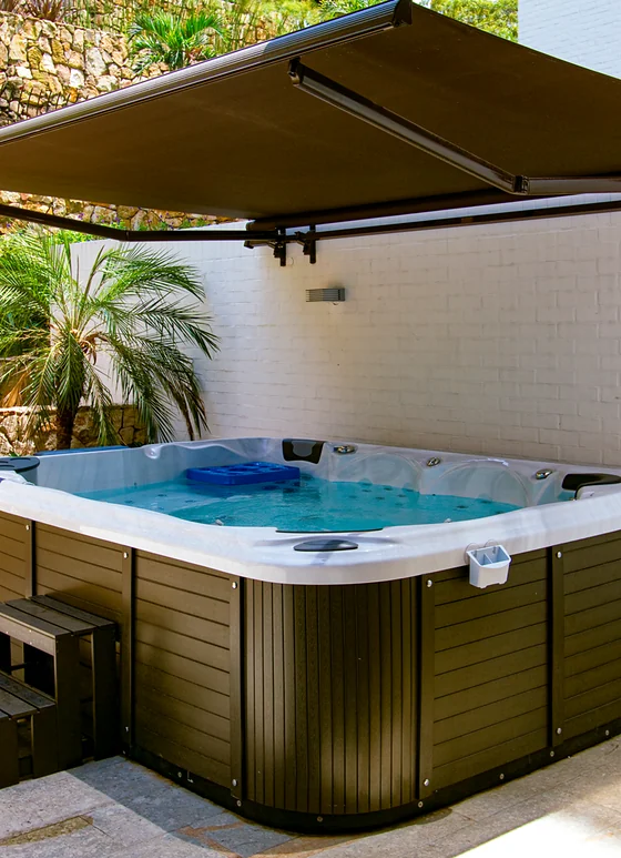 Toldo retráctil Sombralina de brazos sobre un jacuzzi en terraza residencial