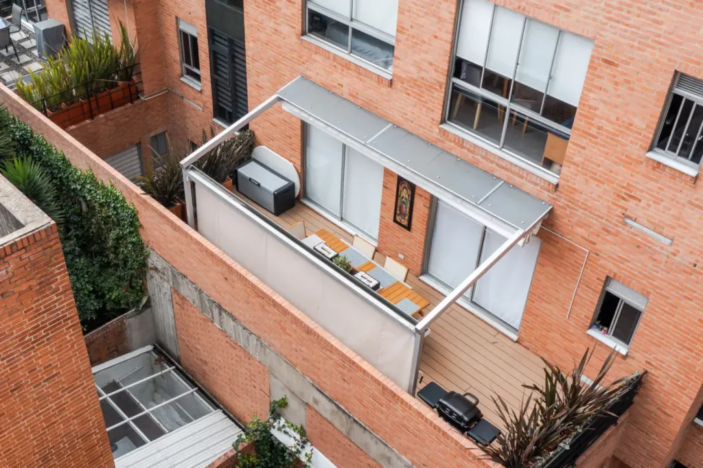 Toldos verticales Baneta Vertical cerrando el perímetro de una terraza y las ventanas de la fachada en Bogotá