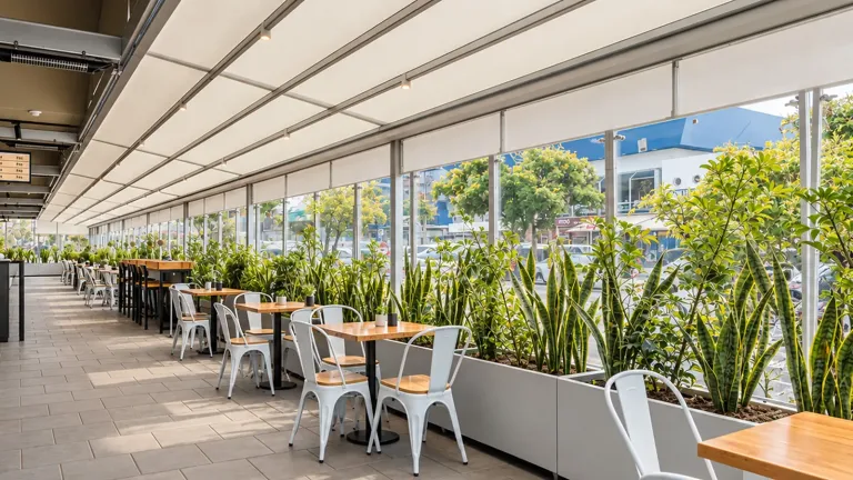Terraza de Carulla cerrada con cortina enrollable, con jardineras interiores