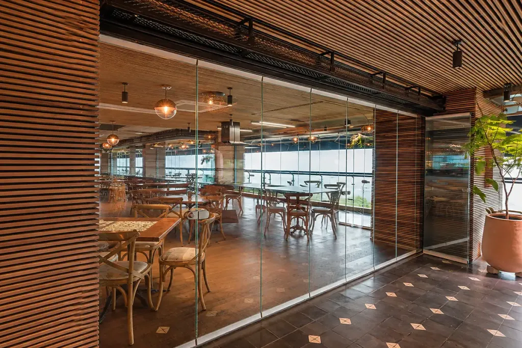 Interior del restaurante con los paneles FlexiGlass plegados y la terraza abierta