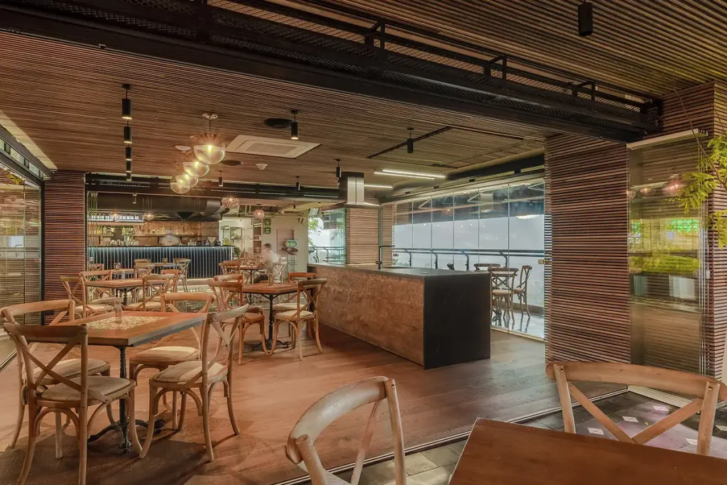 Terraza de restaurante cerrada con FlexiGlass, con la ciudad al fondo tras el vidrio