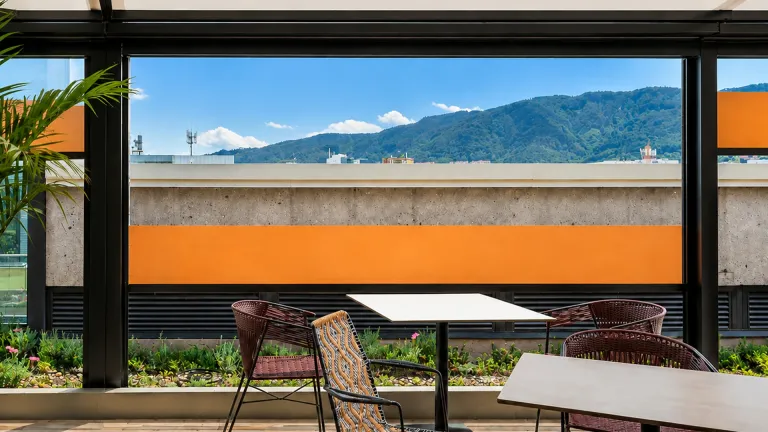 Cerramiento FlexiZipp de paneles transparentes cerrando una terraza con vista a las montañas