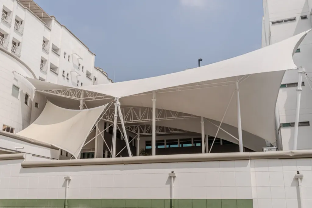 Conjunto de membranas especiales sobre mástiles junto a la fachada de un edificio