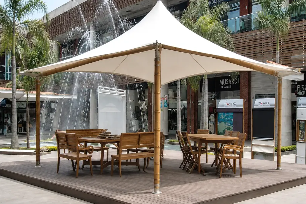 Membrana tipo kiosco con mástiles forrados en guadua sobre la terraza de un jardín residencial