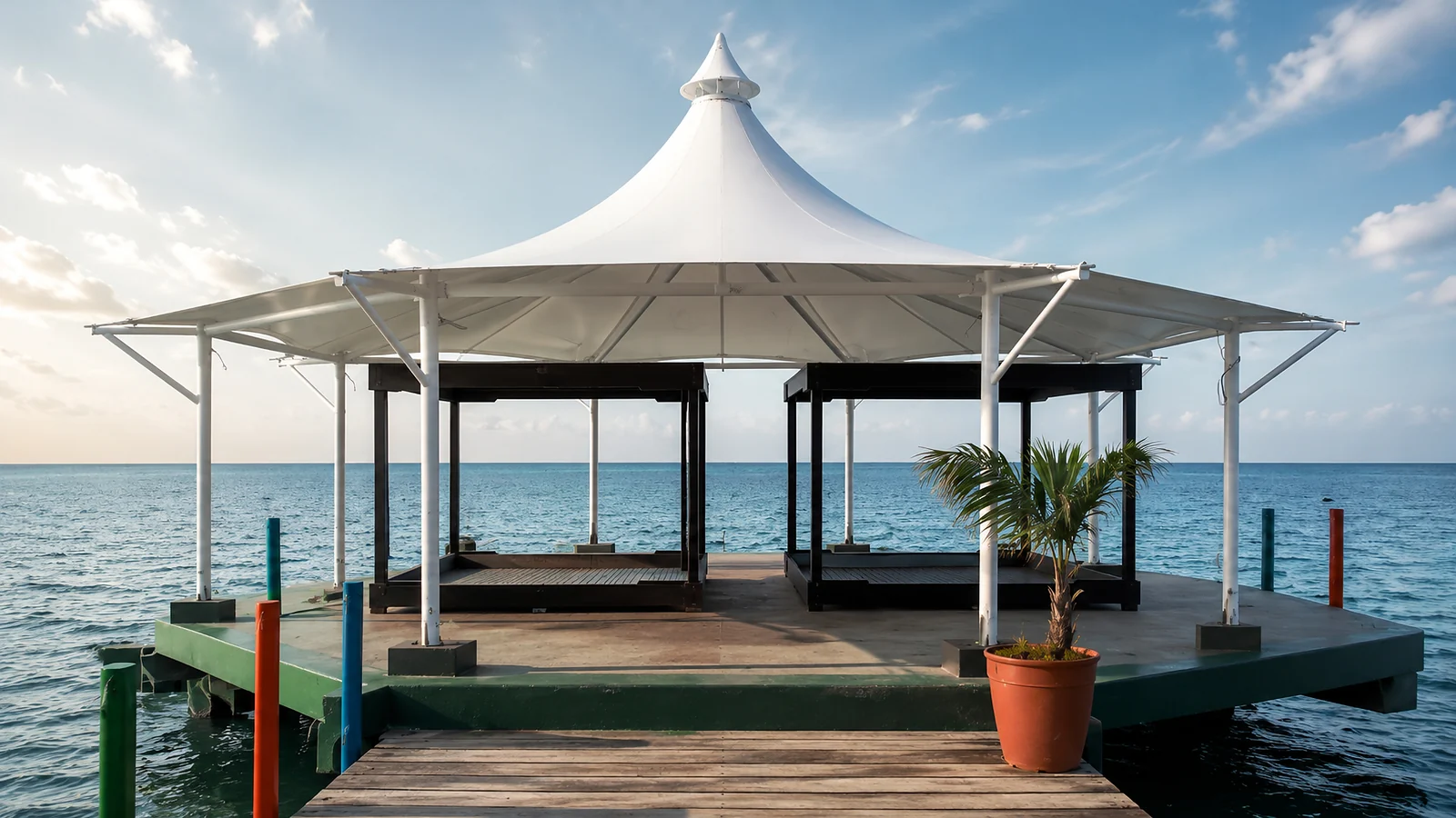 Membrana tipo kiosco cónica sobre una terraza de muelle frente al mar