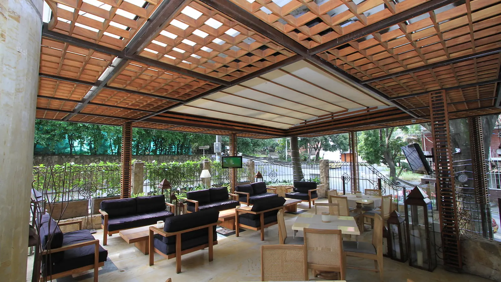 Pérgola fija de estructura en acero con paneles de madera teca sobre una sala de estar exterior