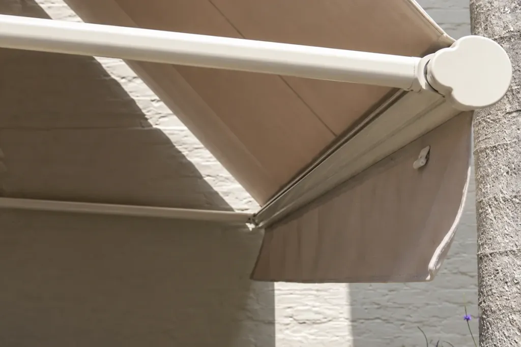 Detalle del brazo y la lona plegada de la pérgola retráctil de Pergamino Café
