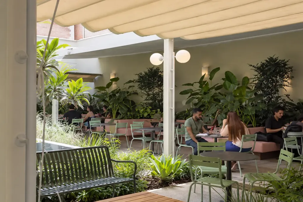 Terraza de Pergamino Café bajo la pérgola retráctil, con clientes en las mesas
