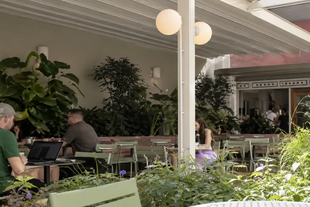 Terraza ajardinada de Pergamino Café cubierta por la pérgola retráctil