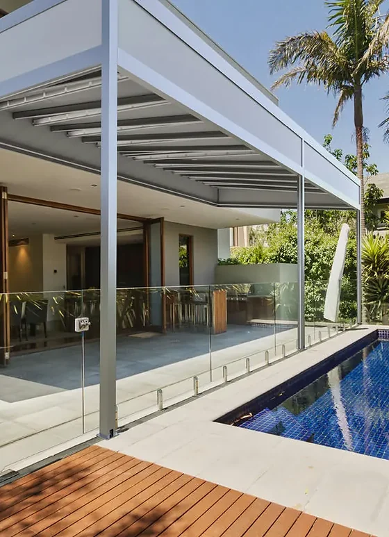 Pérgola retráctil PergoTek Deco con marco perimetral de aluminio sobre una terraza con piscina