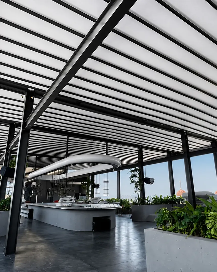 Terraza del rooftop Callao en Cali cubierta con pérgolas PergoTek Romano de lona blanca tensada, con vista a la ciudad
