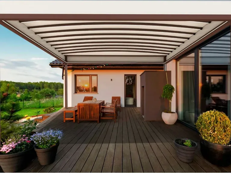 PergoTek Deco Arqueado con la cubierta curva tipo túnel sobre una terraza de madera al atardecer