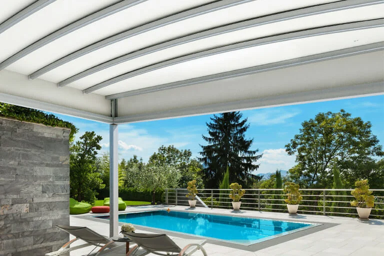 PergoTek Deco Arqueado con la cubierta curva sobre una terraza junto a una piscina de jardín