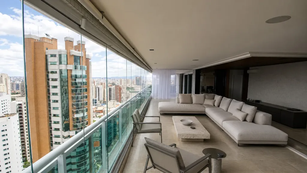 Balcón de apartamento cerrado con FlexiGlass, con la sala de exterior y los edificios de la ciudad al fondo