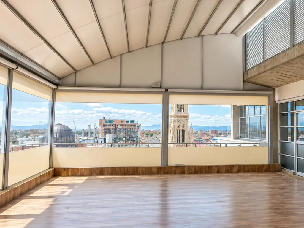 Salón bajo cubierta curva con cortinas FlexiZipp en los vanos y vista a la ciudad