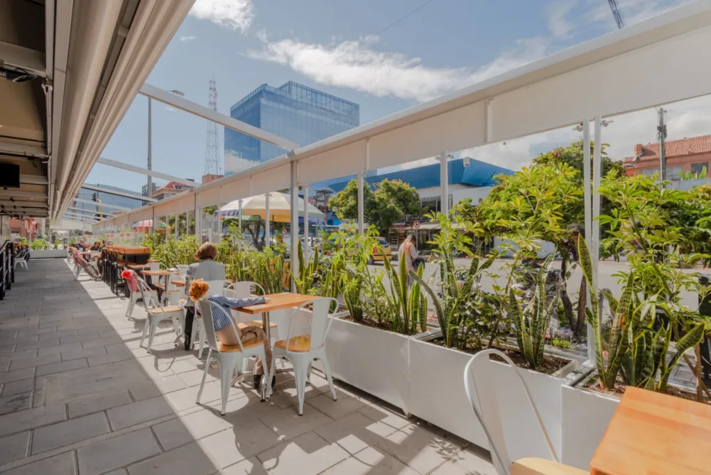 Terraza de Carulla Oviedo en Medellín con la pérgola abierta y jardineras junto a la baranda