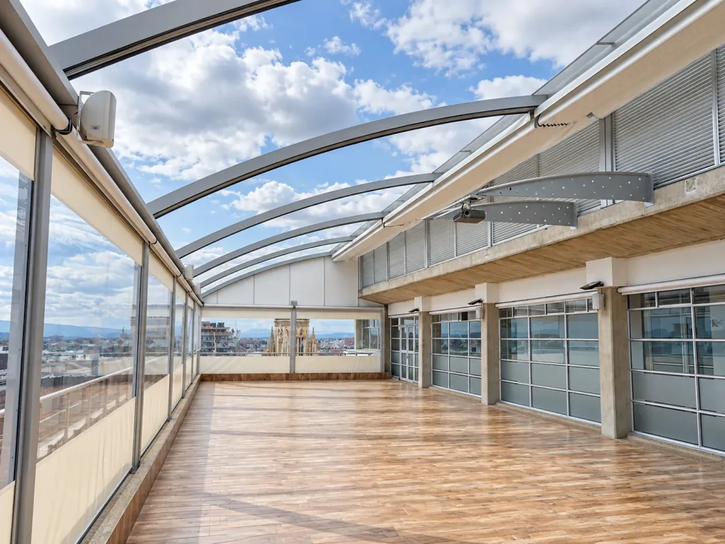 Pérgola retráctil de arcos abierta al cielo en la terraza de la Universidad Konrad Lorenz en Bogotá