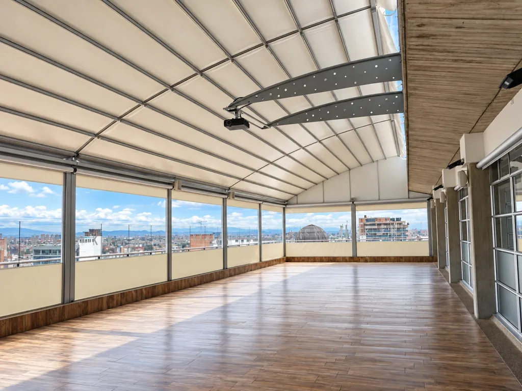 Salón en la azotea de la Universidad Konrad Lorenz bajo la pérgola de arcos cerrada, con cortinas laterales