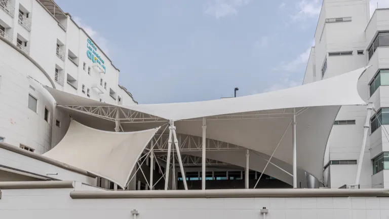 Membrana tensada blanca de gran formato cubriendo la zona común entre los edificios de la Clínica Las Américas en Medellín