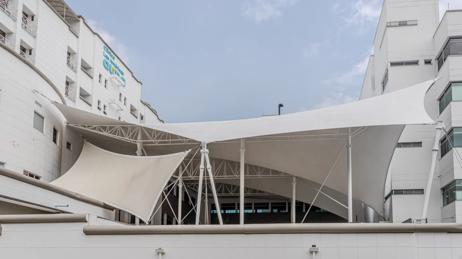 Membrana tensada blanca de gran formato cubriendo la zona común entre los edificios de la Clínica Las Américas en Medellín