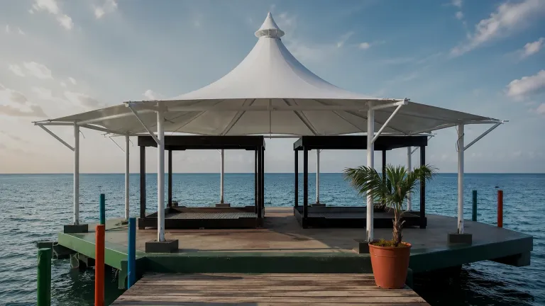 Membrana tipo kiosco cónica sobre una terraza de muelle frente al mar