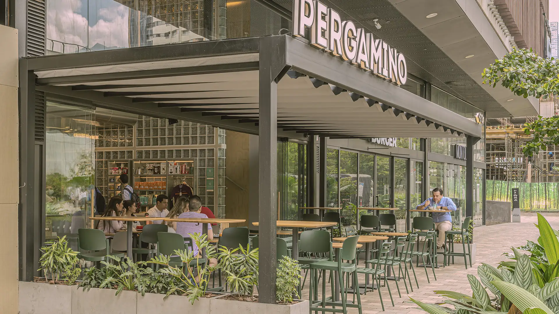 Pérgola sobre la terraza exterior de Pergamino Café, con mesas y clientes