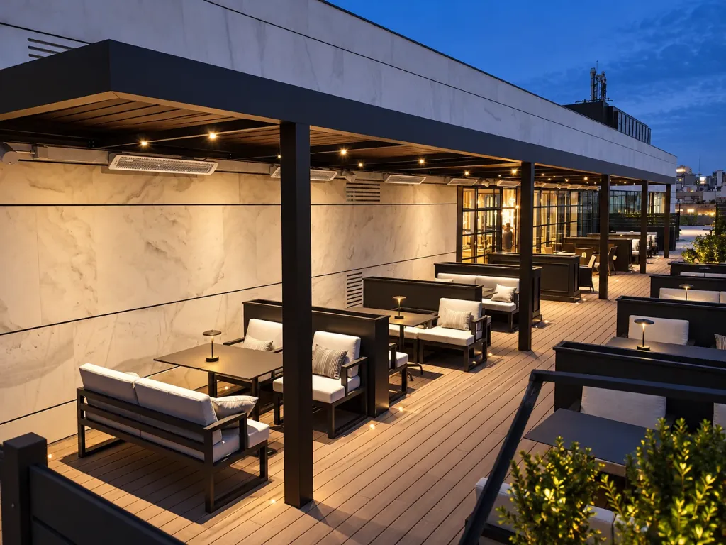 Pérgola bioclimática PergoLam sobre las salas exteriores de una terraza de noche