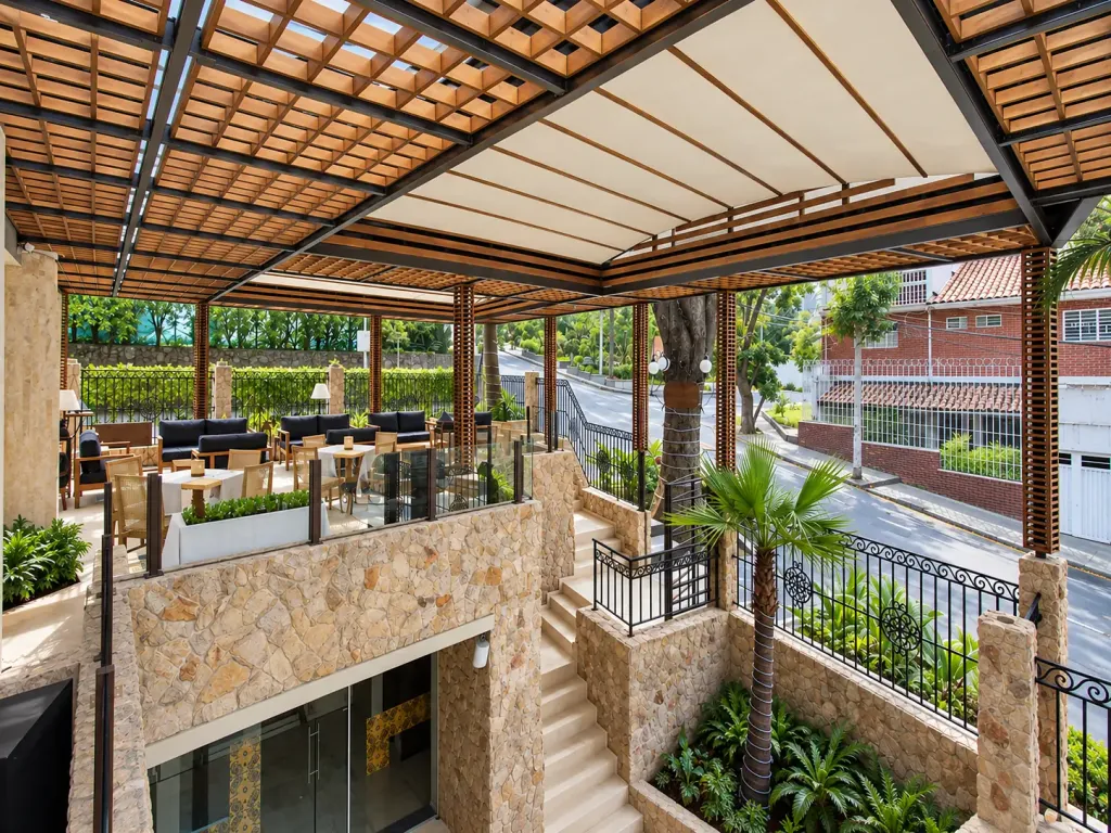Pérgola fija en acero con paneles de teca sobre una terraza con escalera de piedra