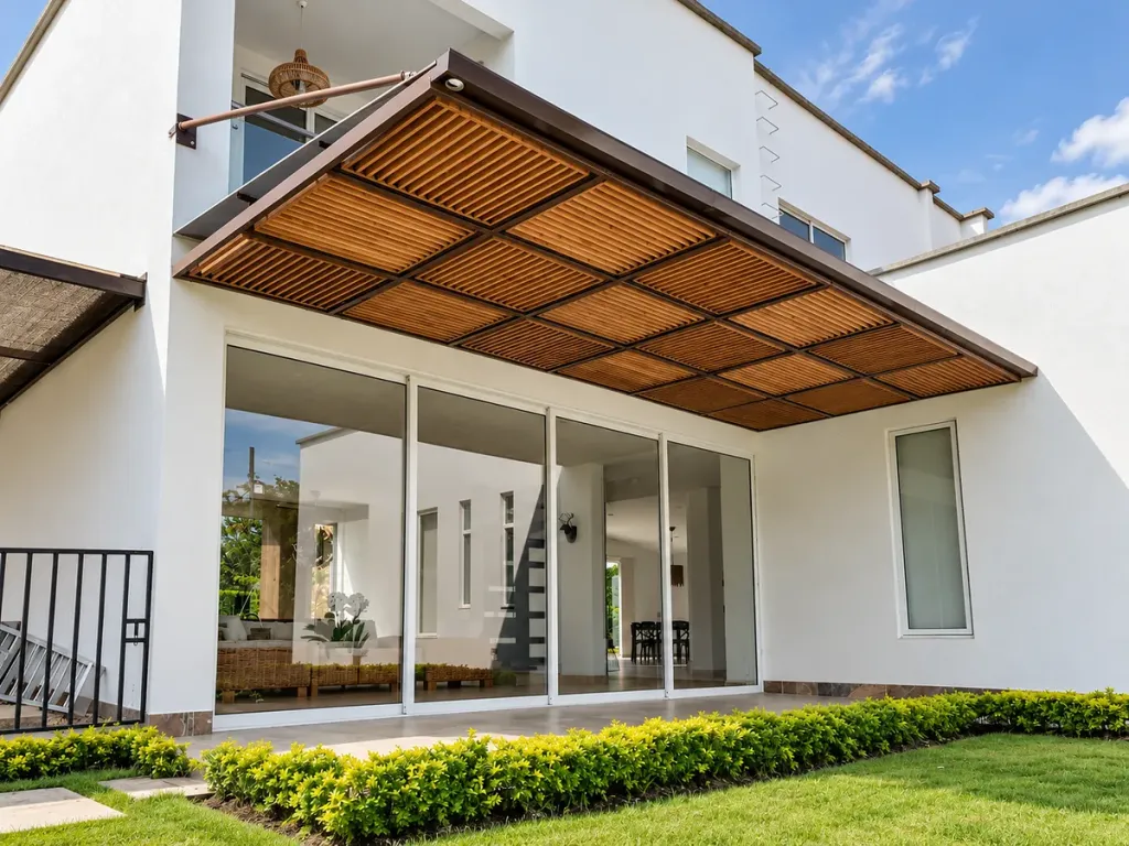 Pérgola fija en acero con panel de teca en voladizo sobre la fachada de una casa