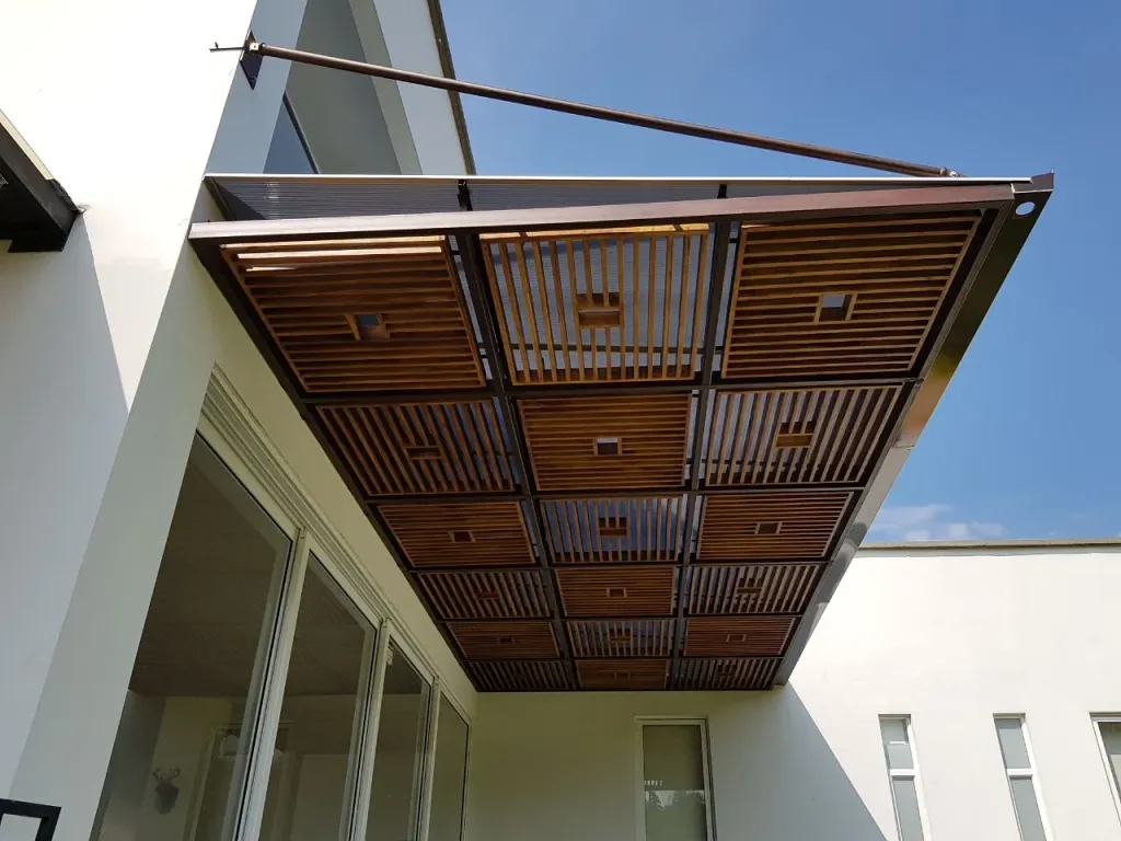Pérgola fija en acero con panel de teca en voladizo sobre una vivienda