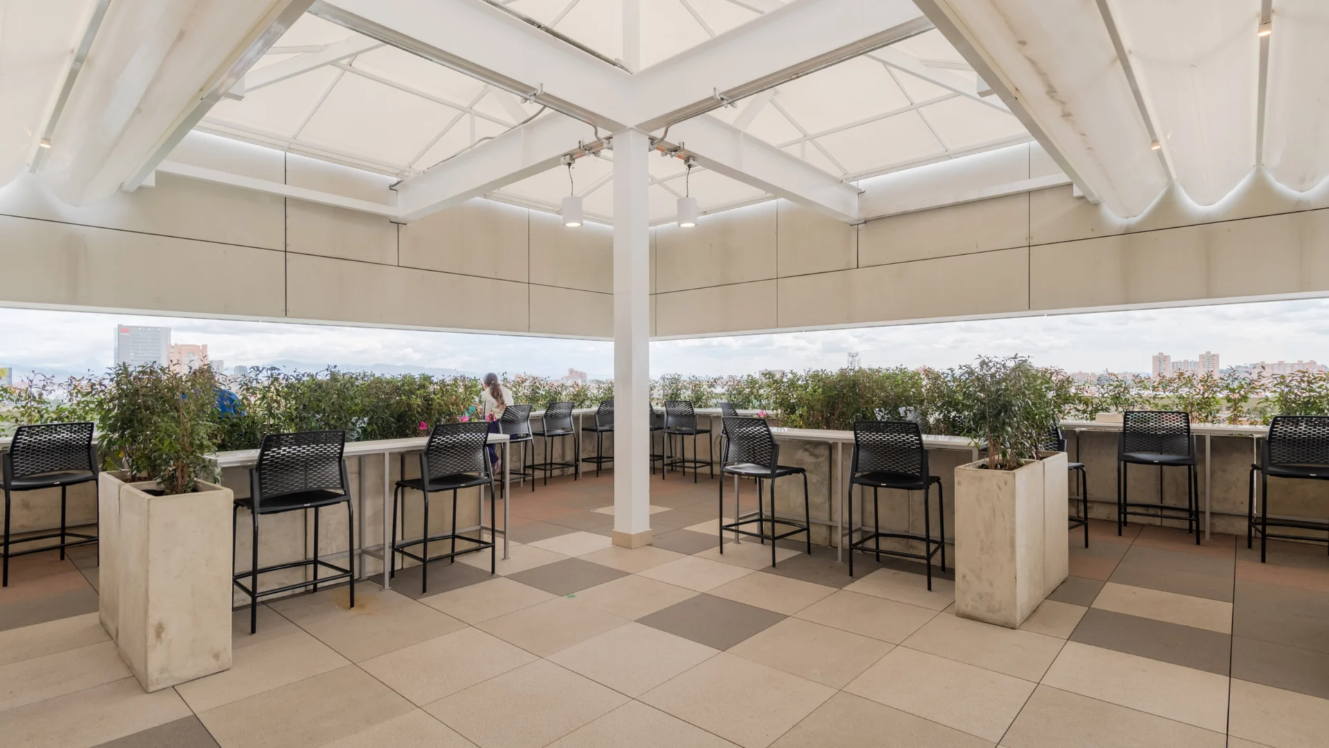 Pérgola PergoTek Romano de lona blanca sobre la terraza de Colmédicas con barras altas y vista a la ciudad