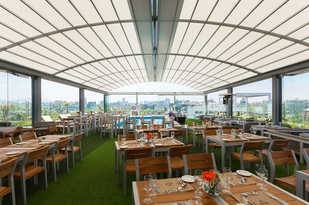 Pérgola retráctil PergoDom de arcos sobre el comedor del rooftop del hotel Noi