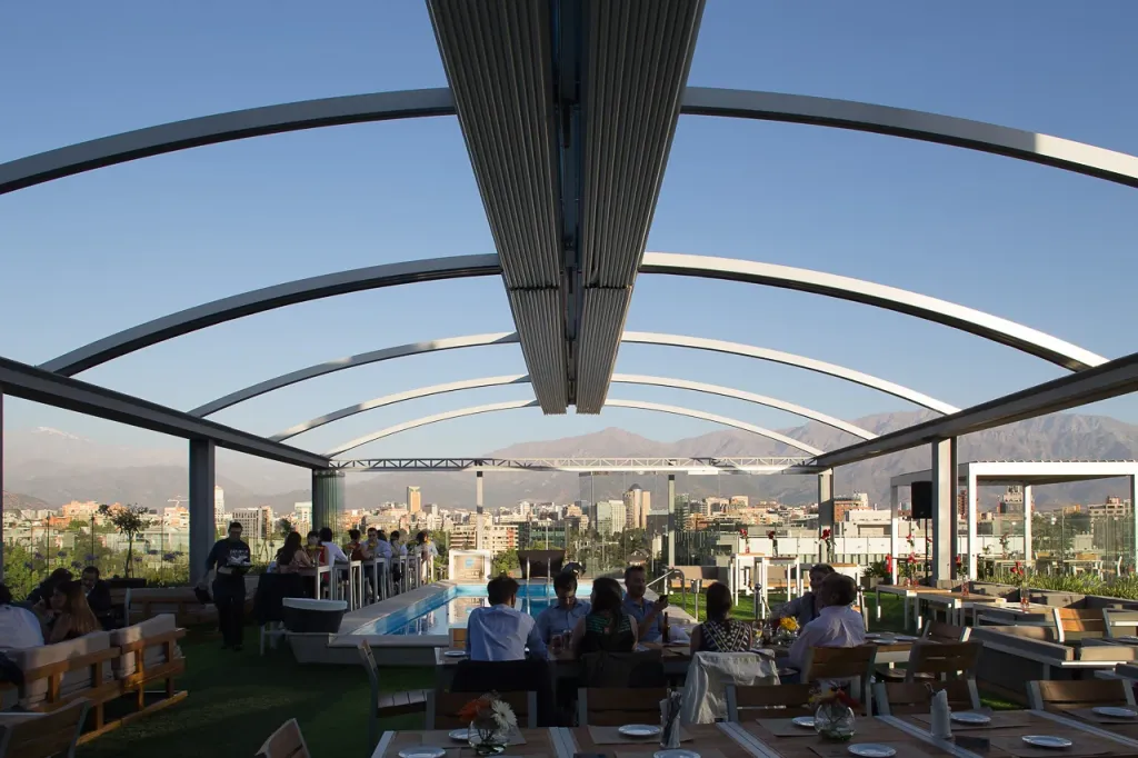 Pérgola retráctil PergoDom de arcos sobre el rooftop del hotel Noi, con clientes