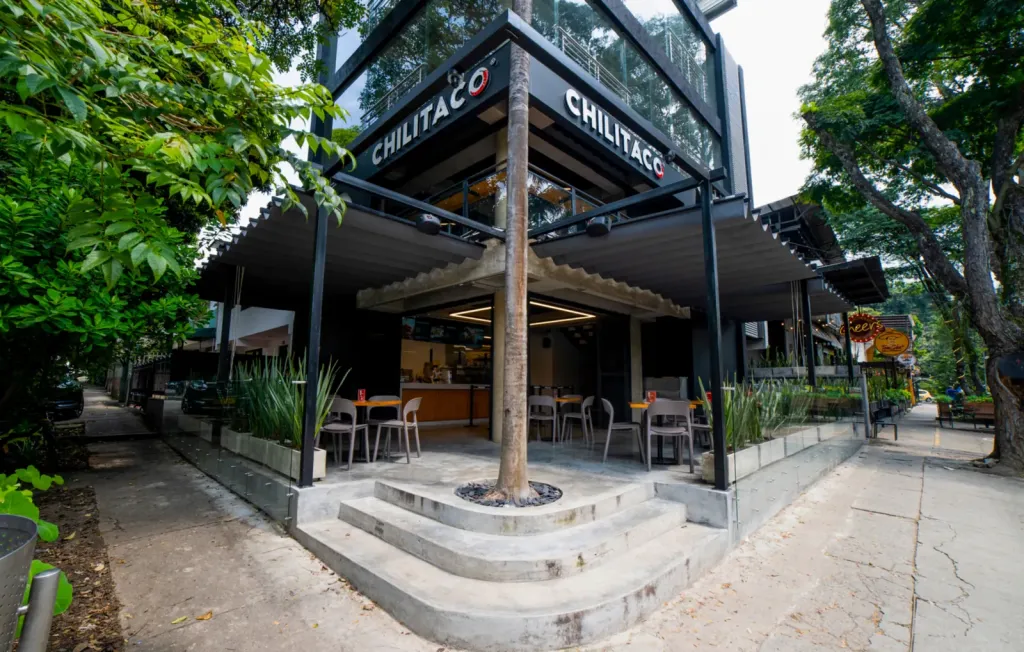 Fachada esquinera del Chilitaco con las pérgolas PergoFlex cubriendo la terraza a pie de calle