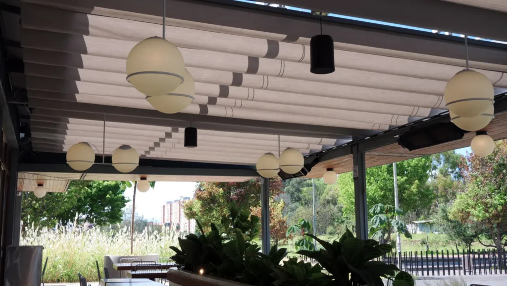 Lona plisada de la Pergolite con lámparas de globo sobre la terraza de Home Burger en Bogotá