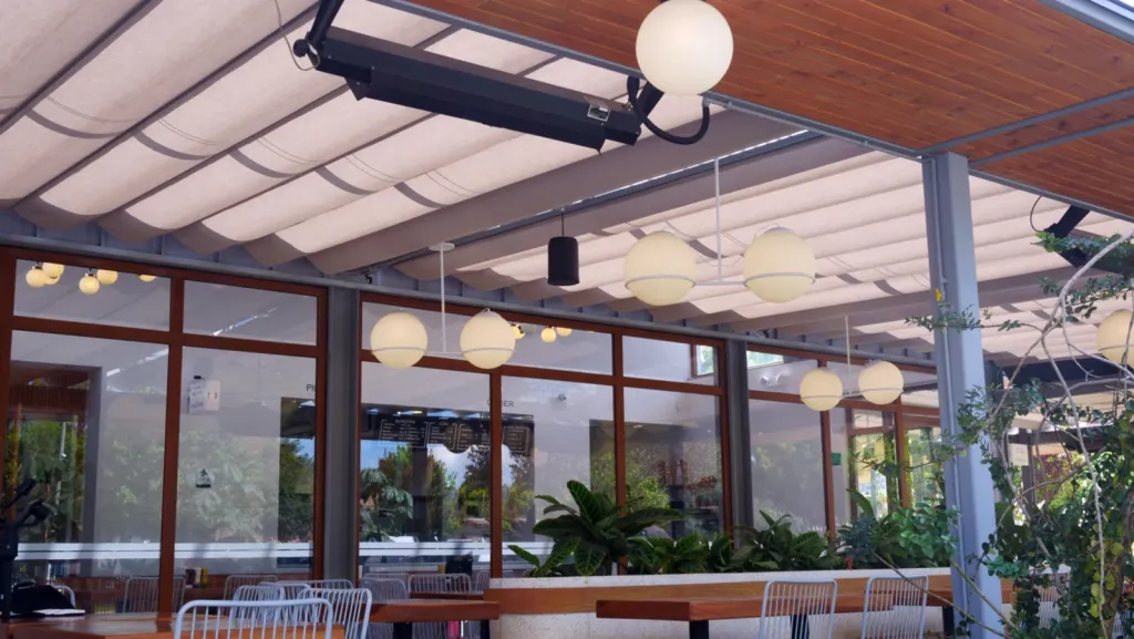 Pergolite extendida frente a la fachada acristalada del salón de Home Burger en Bogotá
