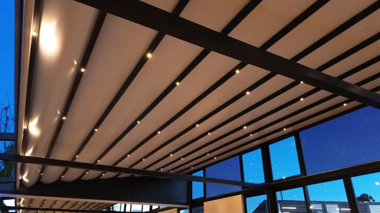 Pérgola retráctil con luces LED integradas encendida al anochecer en la Universidad de La Sabana