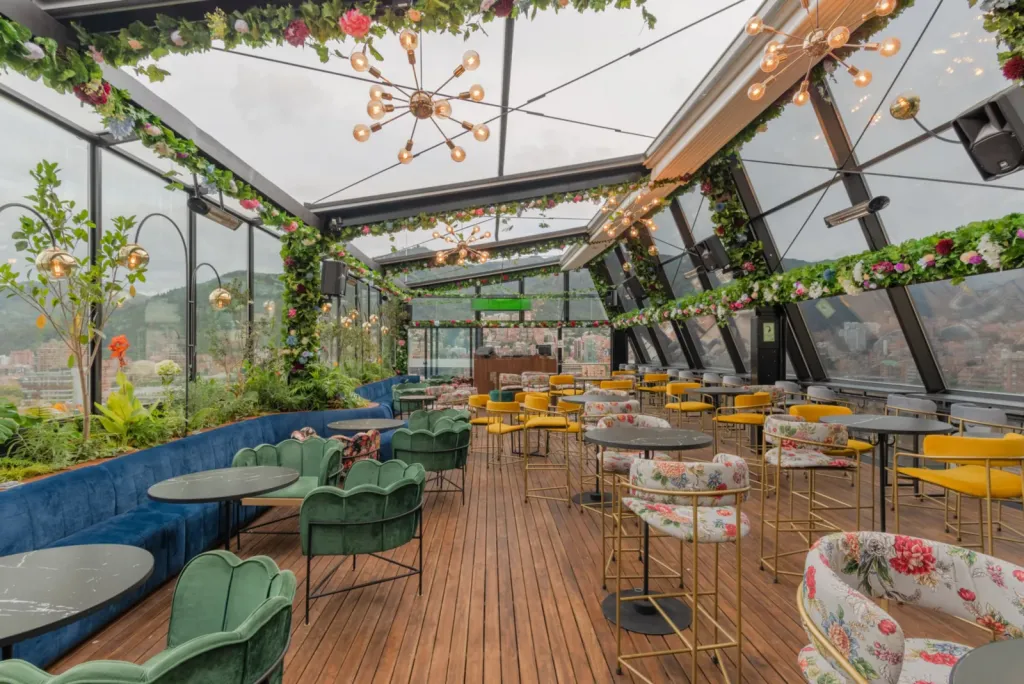 La PergoTek de Mónaco Rooftop recogida, con el cielo abierto sobre las mesas y el cerramiento de vidrio