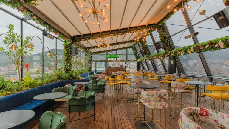 Pérgola retráctil PergoTek cerrada sobre el salón de Mónaco Rooftop, con lámparas y guirnaldas de flores