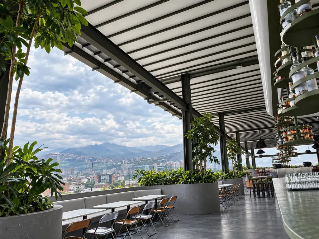 Terraza del rooftop Callao bajo la pérgola PergoTek Romano, con mesas junto a la baranda y vista panorámica de Cali