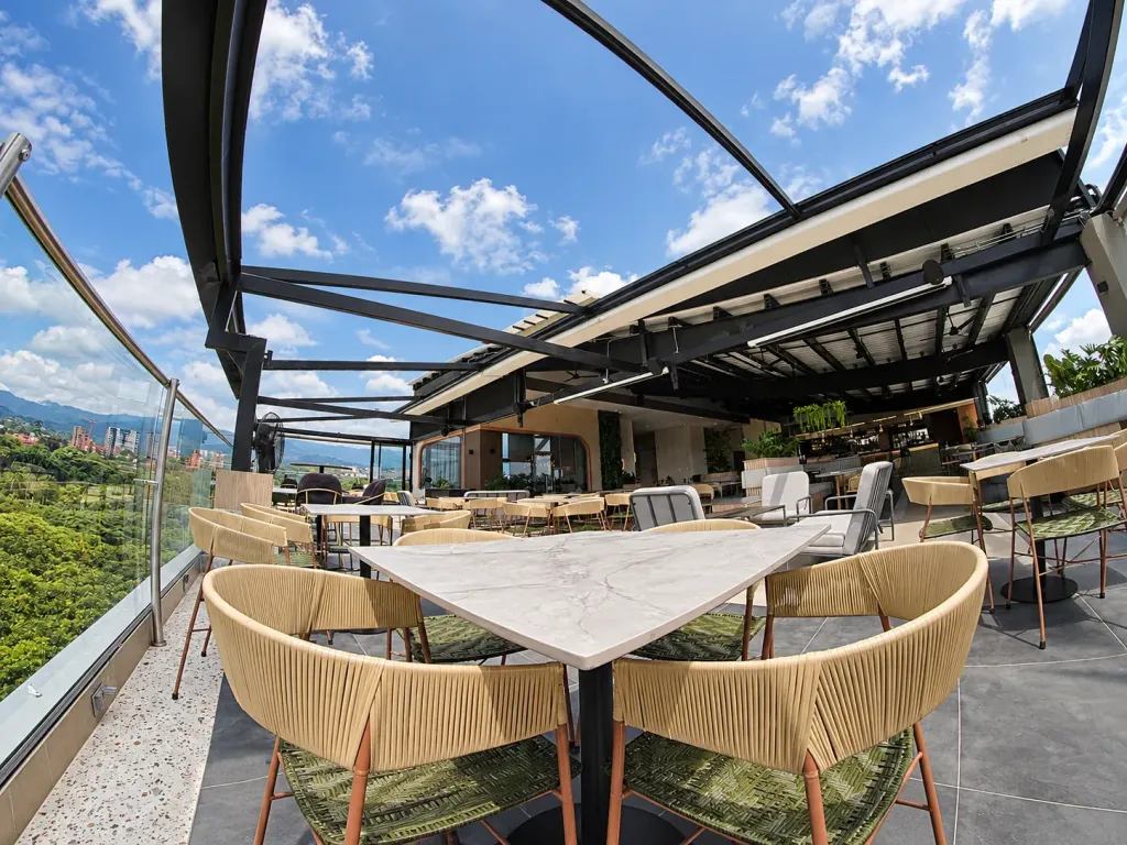 Mesa en la esquina del rooftop de Sabor Molido bajo la estructura de la pérgola PergoTek abierta